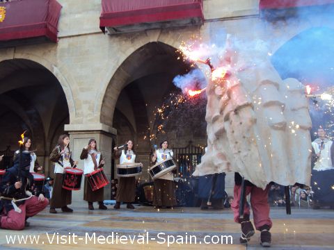 A traditional Catalonian Correfoc or running fire - A fibreglass dragon adorned with burning fireworks dances surrounded by drummers in Medieval costume .Manresa Medieval 2011, Catalonia Spain