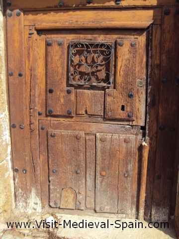 A typical 2 piece front door of a Spanish medieval house (or 3 piece if you include the wooden catflap)