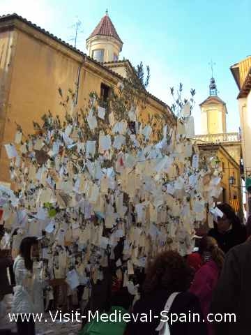 An olive tree is covered with notes containing wishes during the medieval market of vic 2011
